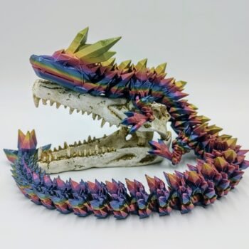 Articulated Crystal Dragon 3D Printed in Blue Mountains Rainbow Articulated Crystal Dragon Sensory Toy in Silk Blue Mountains Rainbow Sitting on a Fake Skull Closeup with a White Background