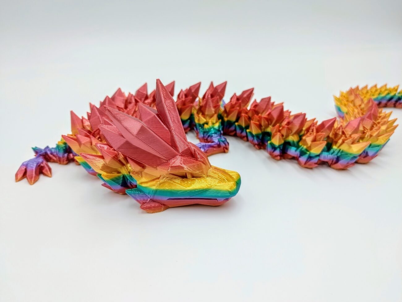 Articulated Crystal Dragon 3D Printed in Coober Pedy Rainbow Articulated Crystal Dragon Sensory Toy in Silk Coober Pedy Rainbow with a White Background Closeup with a White Background