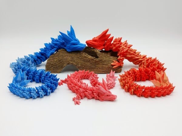 Articulated Crystal Dragon 3D Printed in Matte Dual Tone Colours Articulated Crystal Dragon Sensory Toys in Matte Ice to Blue and Yellow to Red and Pink to Red Sitting on a Log On a White Background