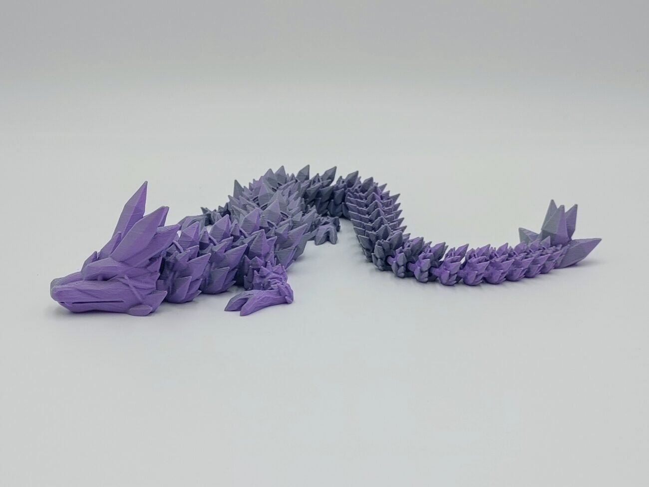 Articulated Crystal Dragon 3D Printed in Matte Purple to Grey Articulated Crystal Dragon Sensory Toy Designed by Cinderwing3d in Matte Purple to Grey with a White Background