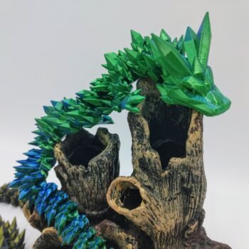Articulated Crystal Dragon 3D Printed in Silk Blue to Green Articulated Crystal Dragon Sensory Toy in Silk Blue to Green Sitting on Coral with a White Background