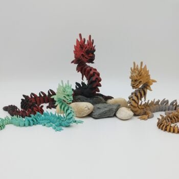 Articulated Imperial Dragon 3D Printed in Matte Multi Tone Hues Articulated Imperial Dragon Sensory Toys in Matte Multi Tone Hues Sitting on Rocks with a White Background