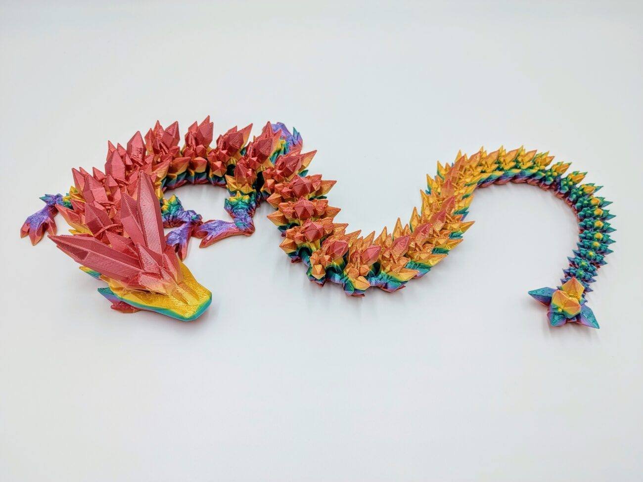 Crystal Dragon 3D Printed in Coober Pedy Rainbow Articulated Crystal Dragon Sensory Toy in Silk Coober Pedy Rainbow with a White Background